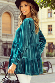 Turquoise velvet tiered blouse with puffed sleeves and ruffled cuffs.