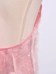 Pink iridescent sequin halter mini dress with sheer overlay and pink trim.
