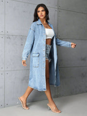 Medium wash denim duster coat with utility pockets and button front, worn open over shorts.