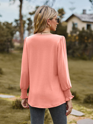 Coral gathered yoke peplum sleeve top with smocked cuffs.