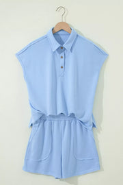 Light blue sleeveless polo shirt and shorts set with button detail and pockets.