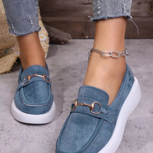 Blue suede loafers with gold horse-bit detail and white soles.