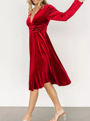 Red velvet midi dress with V-neck, long sleeves, and ruched waist detail.