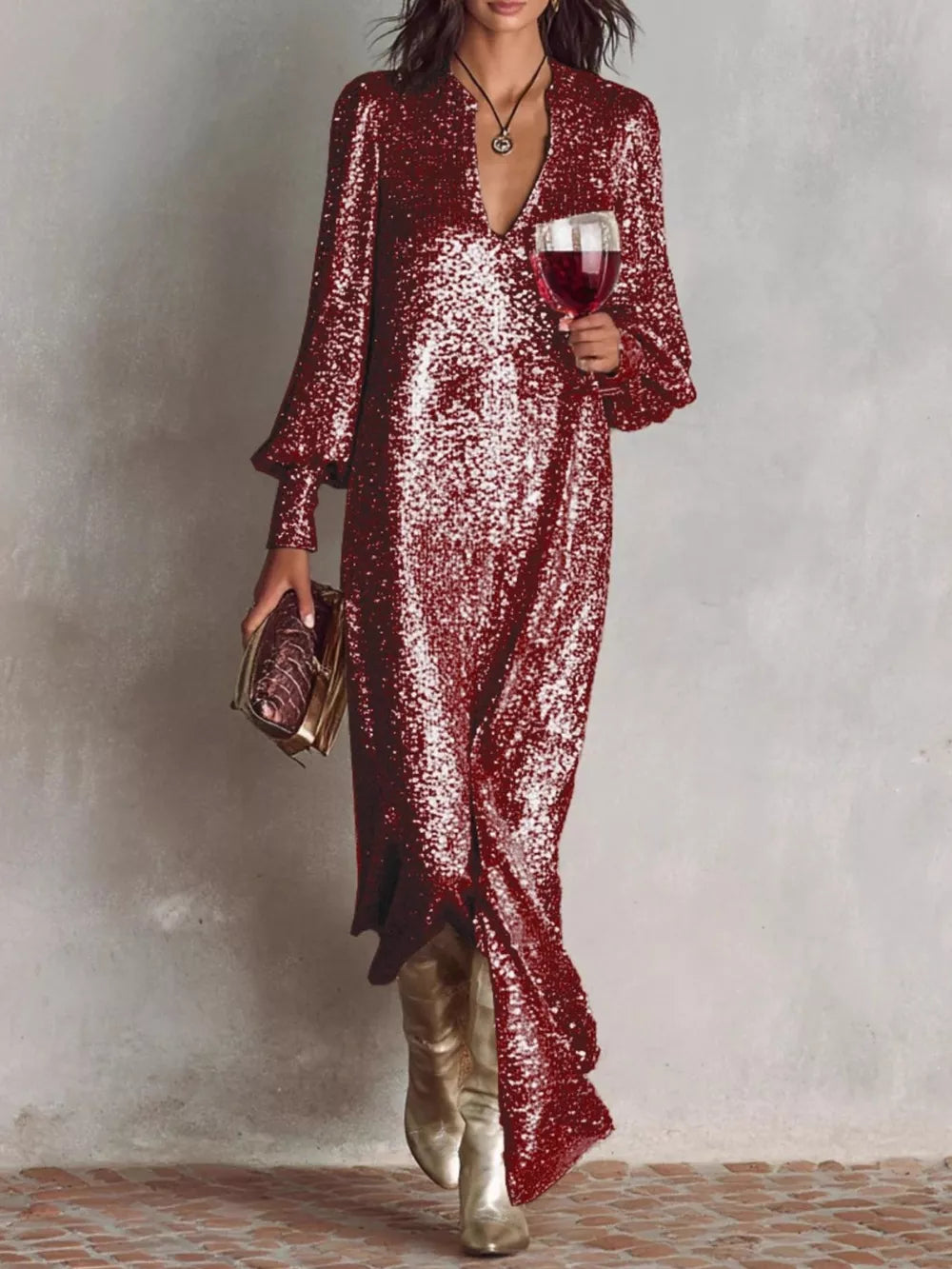 Wine red sequin maxi gown with lantern sleeves and a V-neck, styled with gold boots and clutch.