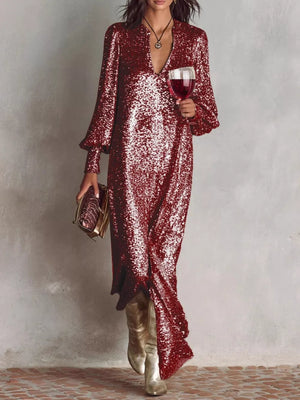 Wine red sequin maxi gown with lantern sleeves and a V-neck, styled with gold boots and clutch.