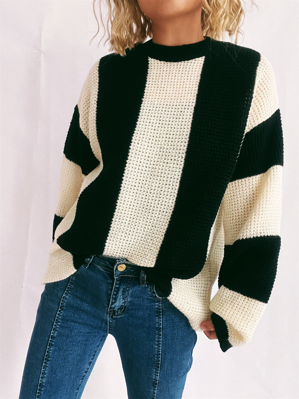 Black and cream vertical stripe waffle knit sweater with crew neck.