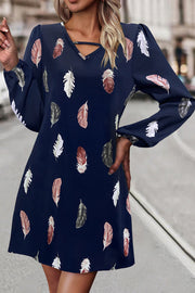 Navy feather print mini dress with cutout neckline and long sleeves.