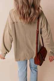 Tan waffle knit overshirt with patch pockets and a collar, styled with light wash jeans.