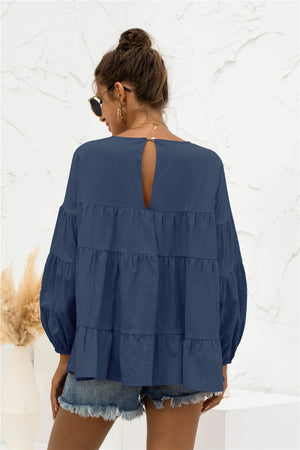 Navy tiered peasant blouse with ruffled bubble sleeves and keyhole back detail.