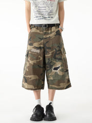 Men's camo cargo denim shorts with distressed patches and raw hem