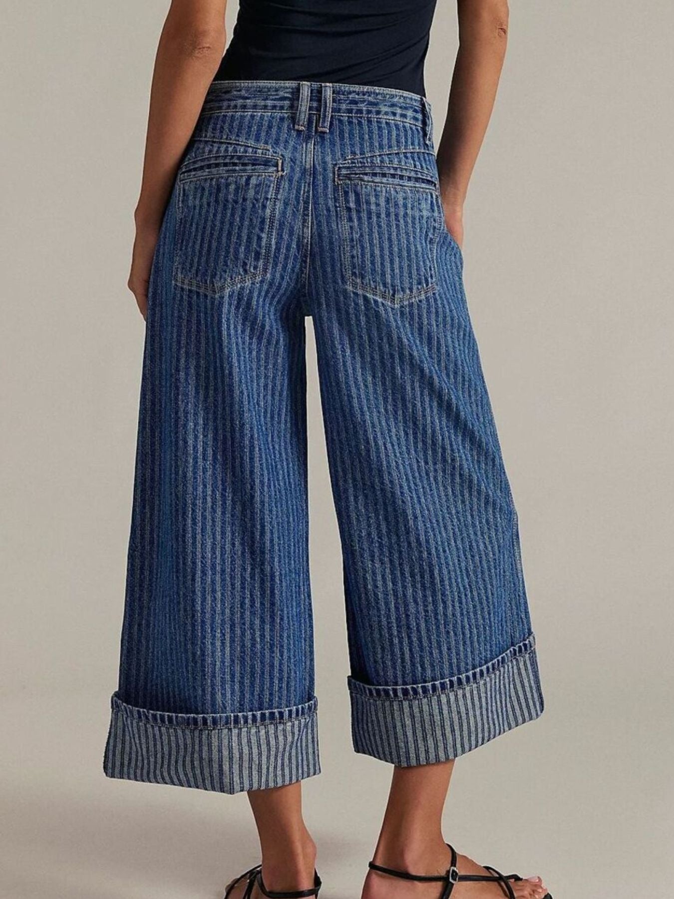 Dark blue striped cropped jeans with wide leg and cuffed hem.