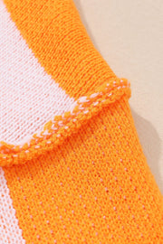 Checkerboard knit sweater in tangerine and white with textured trim detail.