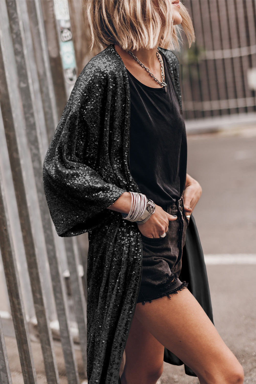 Black sequin kimono jacket with wide sleeves and open front, styled with a black top and shorts.