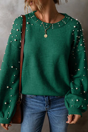 Dark green knit sweater with pearl embellishments on the neckline and sleeves.