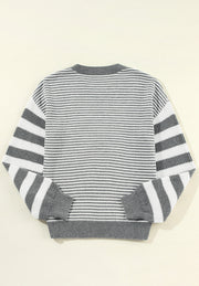 Gray and white striped knit sweater with crew neck and ribbed cuffs and hem.