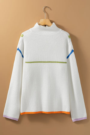 White ribbed knit sweater with colorblock details, mock neck, and striped hem.