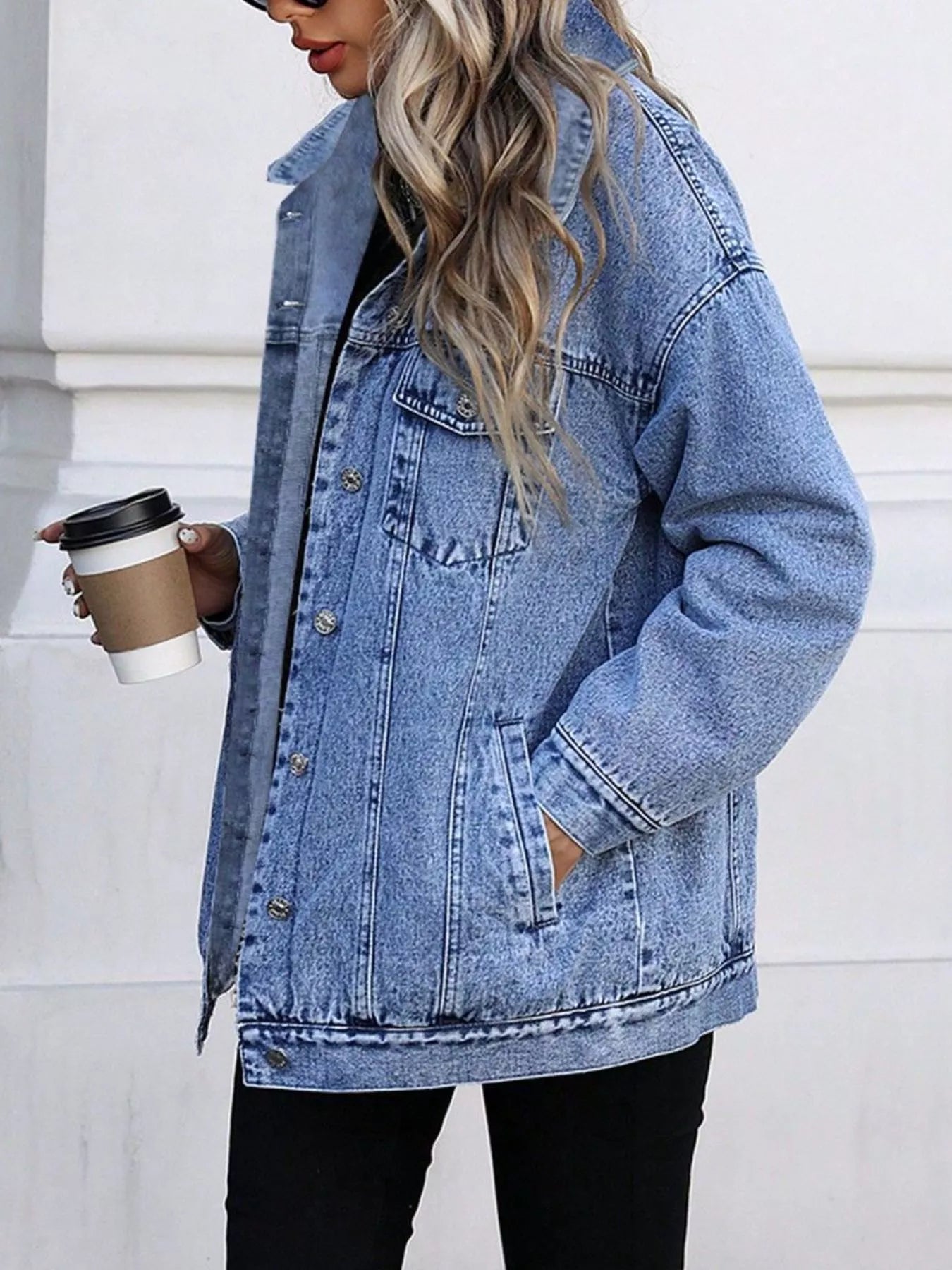 Oversized washed blue denim jacket with button front and pockets.