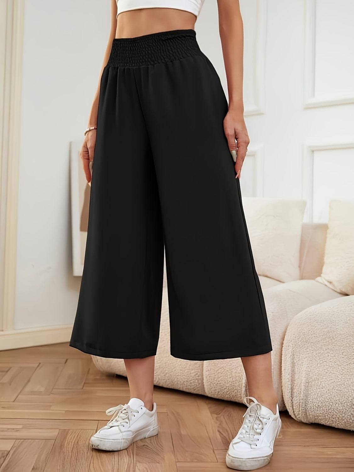 Black smocked waist culotte trousers with a wide leg and cropped length.