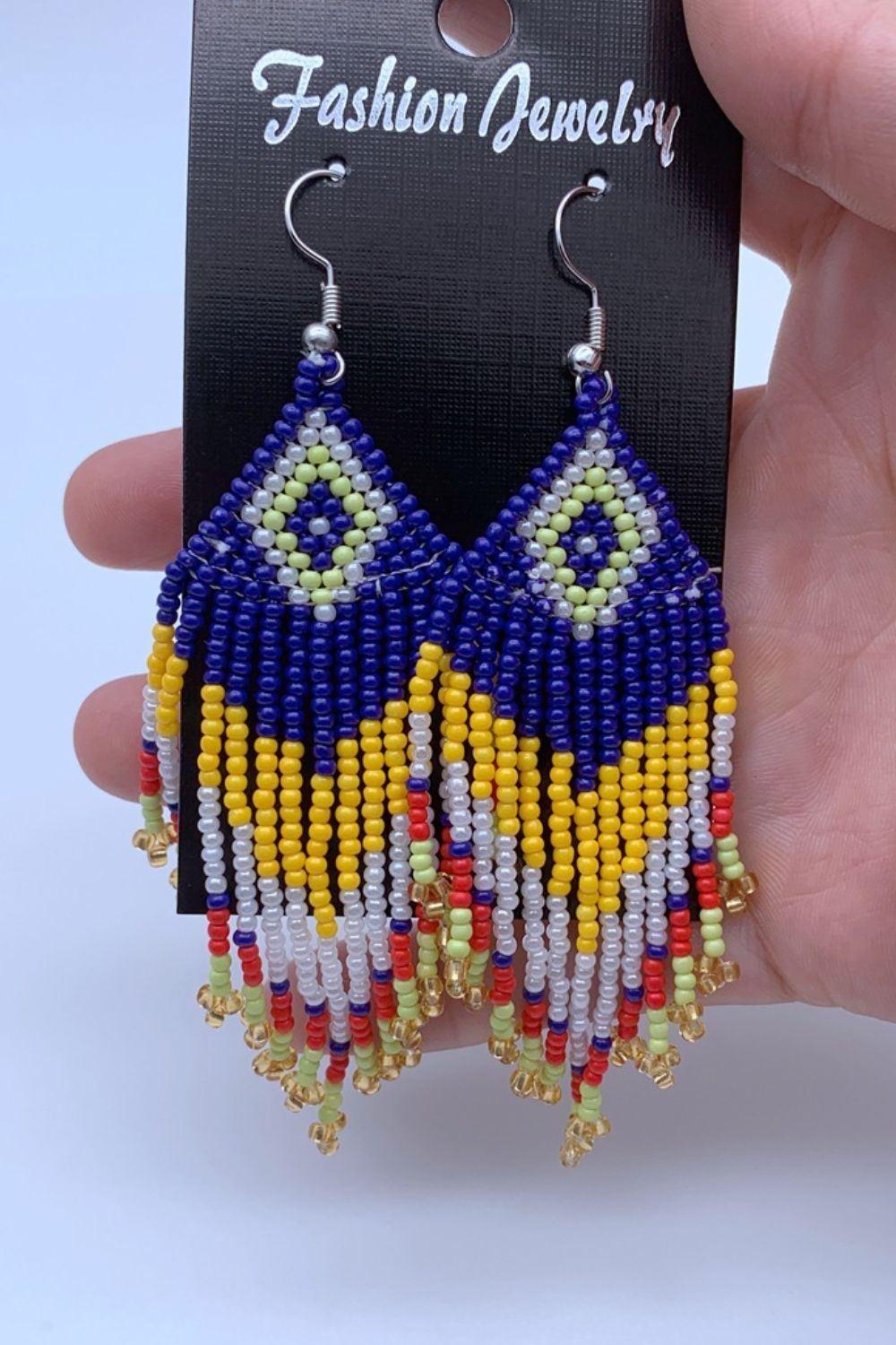 Beaded diamond fringe earrings in blue, yellow, white, red, and green with gold accents.