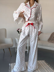 White cotton pajama set with red hearts, button front top and wide leg pants with ruffle hem.