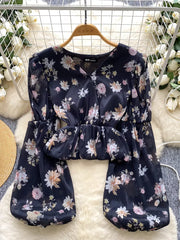Black floral chiffon blouse with balloon sleeves and cropped peplum hem.