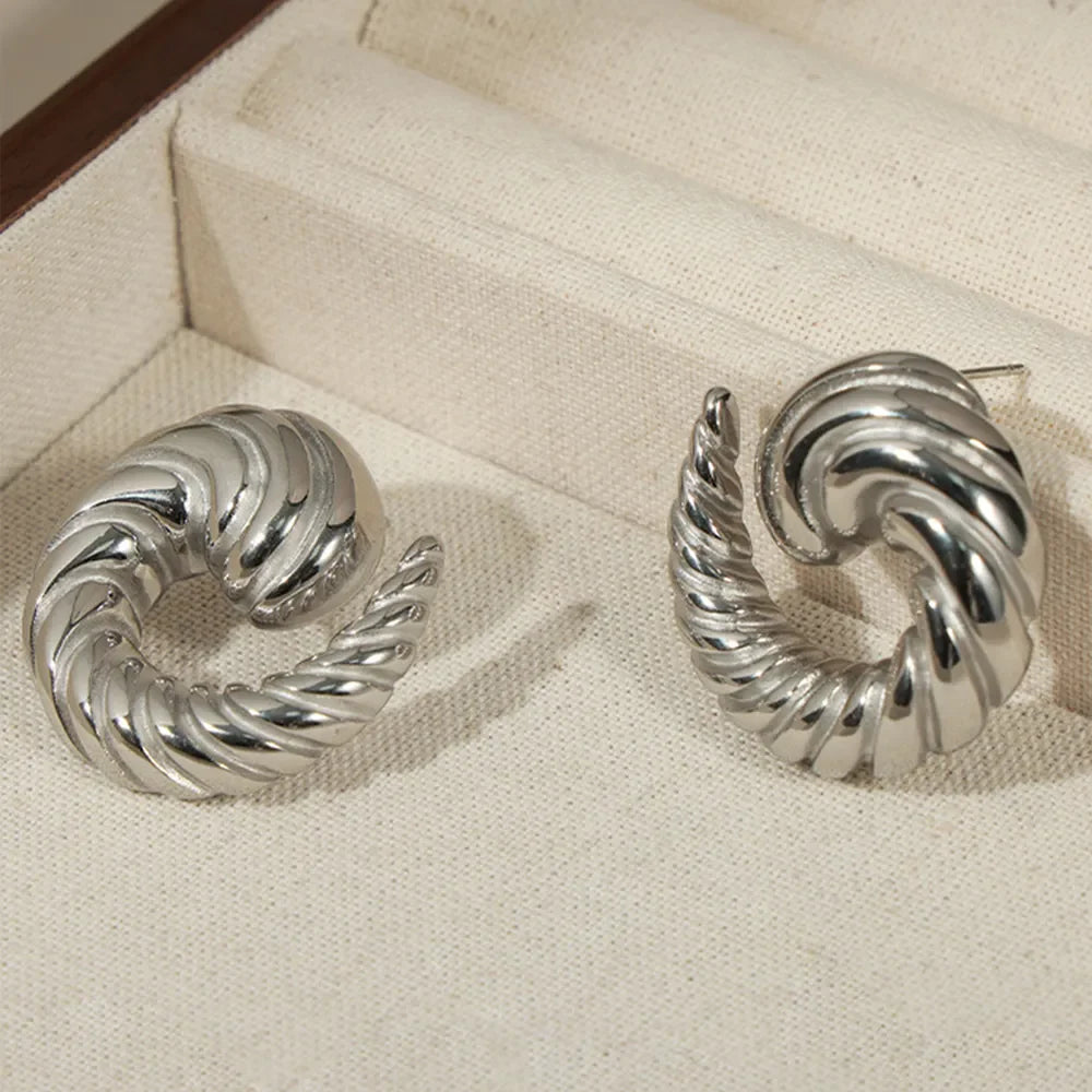 Silver sculptural swirl stud earrings with a twisted, textured design.