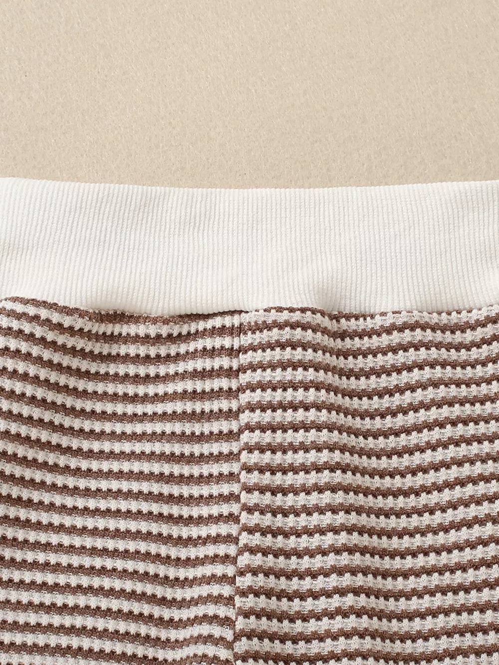 Baby knit set with brown and white stripes and a white ribbed waistband.