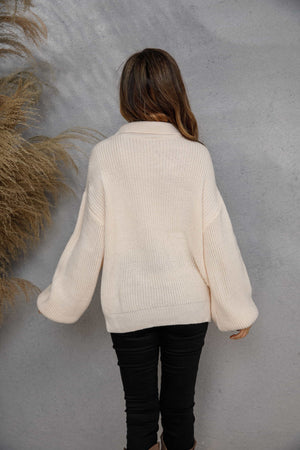 Ivory ribbed knit half-zip pullover sweater with balloon sleeves.