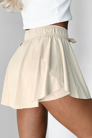 Beige ruffled skort with tie waist detail and elastic waistband.