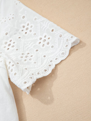 White cotton eyelet embroidered sheer shirt with floral detail and scalloped hem.