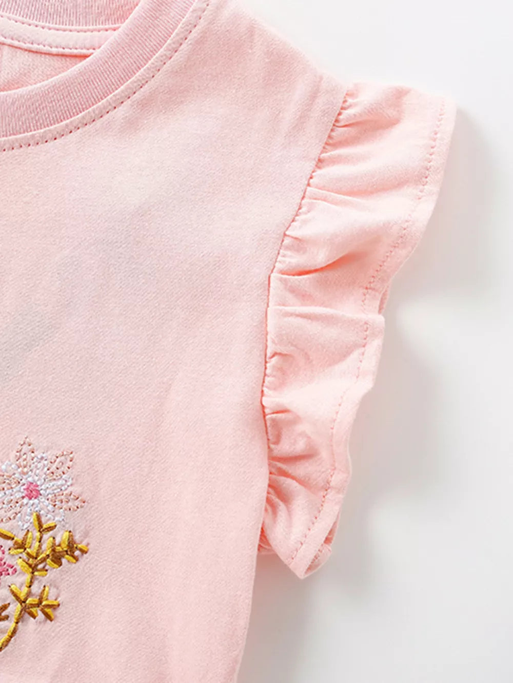 Pink cotton baby dress with embroidered flowers and ruffle cap sleeves.