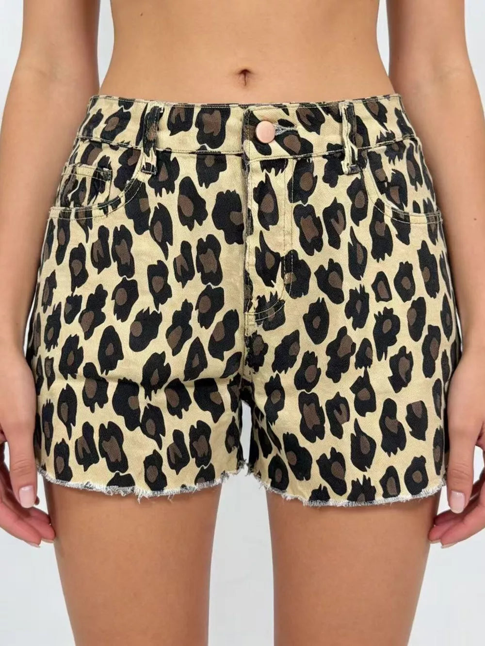 Leopard print high-waisted denim shorts with raw hem and button closure.