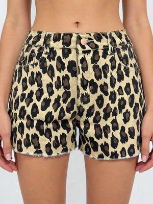Leopard print high-waisted denim shorts with raw hem and button closure.