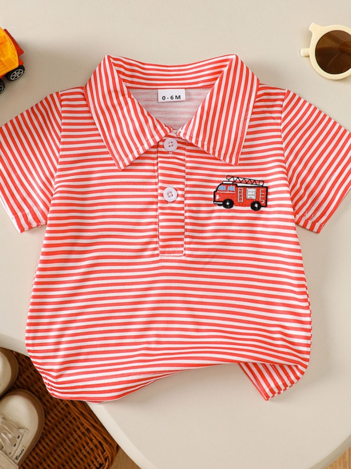 Red and white striped baby polo shirt with embroidered firetruck detail.
