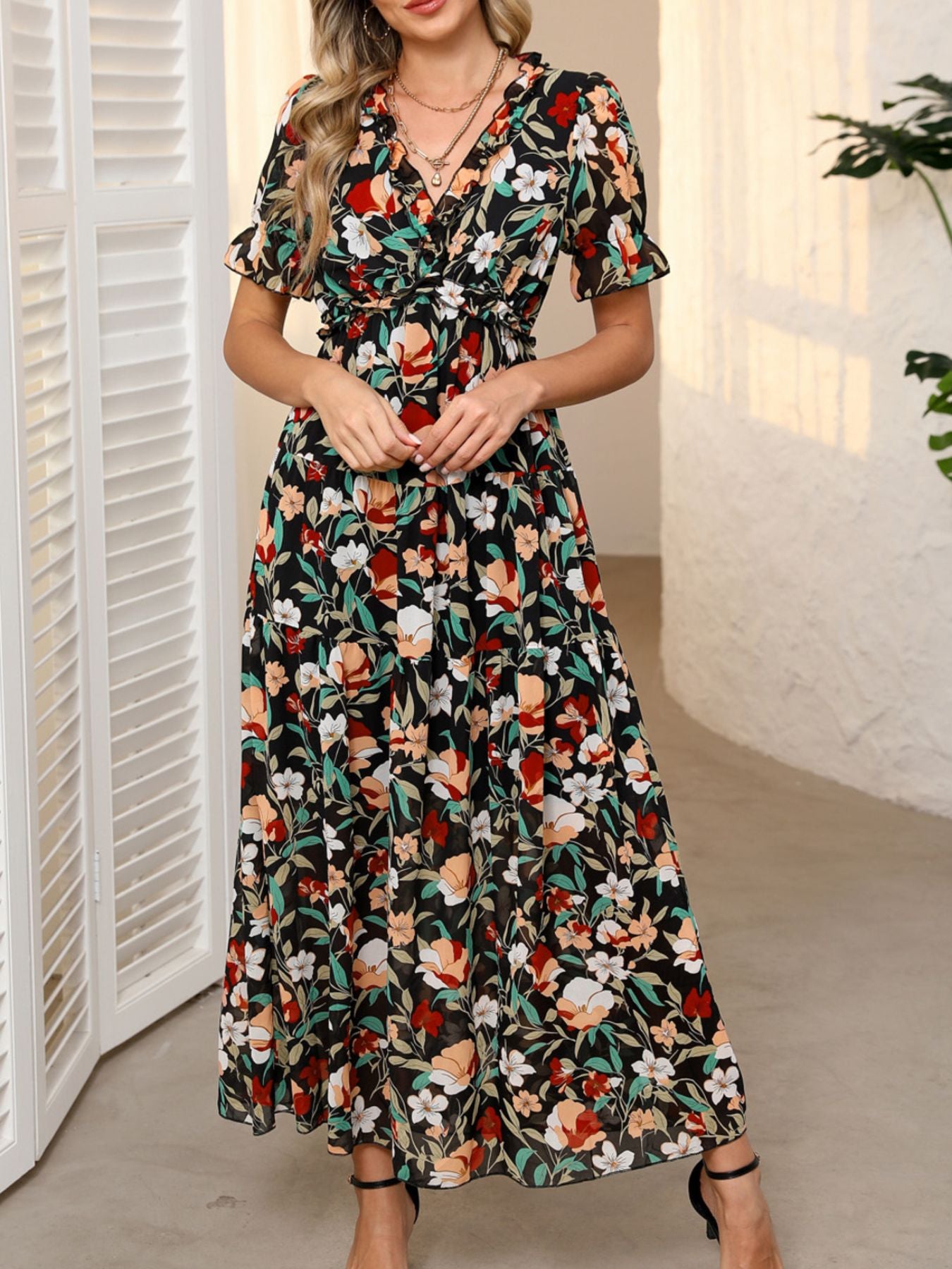 Black floral print maxi dress with ruffled V-neck, cinched waist, and short flutter sleeves.