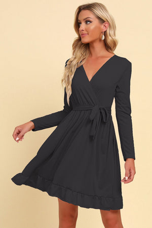 Black wrap dress with V-neck, tie waist, long sleeves, and ruffled hem.