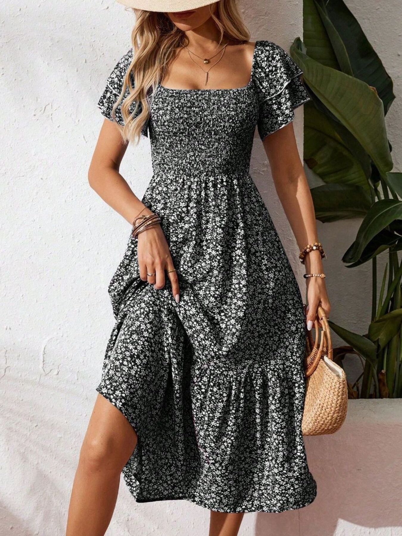 Black floral smocked midi dress with ruffle sleeves and tiered skirt.