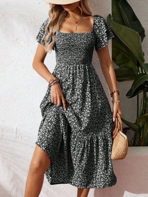 Black floral smocked midi dress with ruffle sleeves and tiered skirt.