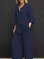 Navy blue relaxed two-piece set with buttoned collared top and wide-leg pants.