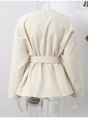 Beige belted trench coat with dropped shoulders and tie waist detail.