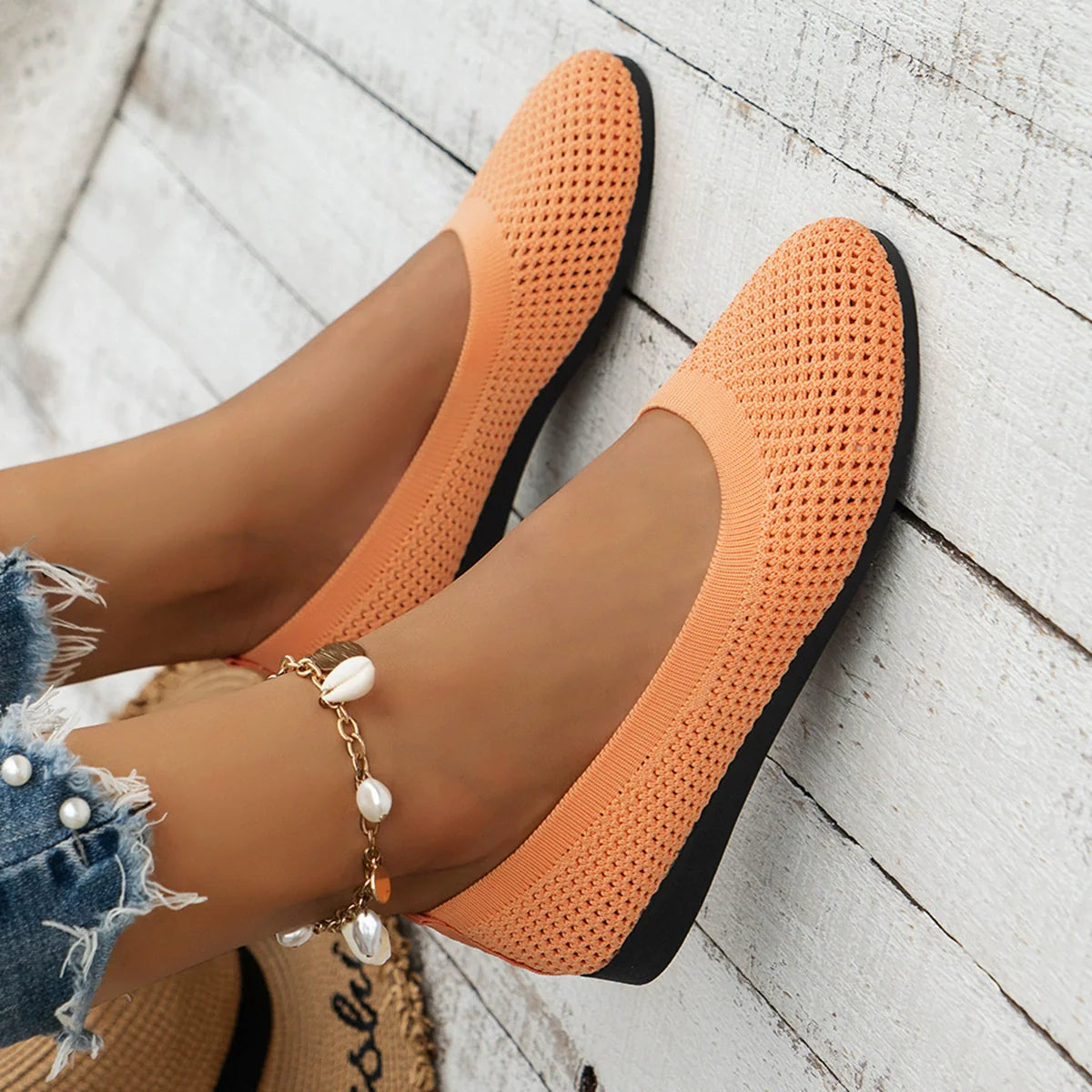 Tangerine breathable knit ballet flats with a perforated texture and black sole.