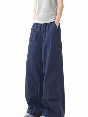 Men's dark navy lightweight cargo pants with wide leg and buttoned pockets.