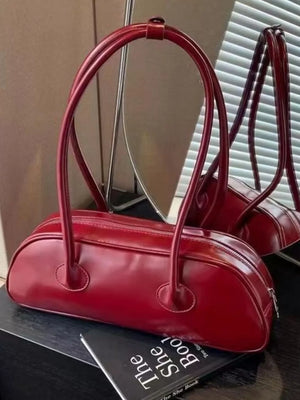 Chic red barrel shoulder bag with double top handles and a zip closure.