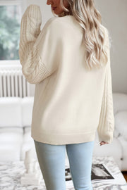 Cream cable-knit sleeve relaxed fit sweater with crew neck and ribbed cuffs.