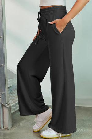 Black palazzo joggers with drawstring waist and center seam detail.