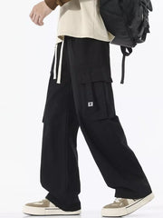 Black cotton cargo sweatpants with wide legs and drawstring waist.