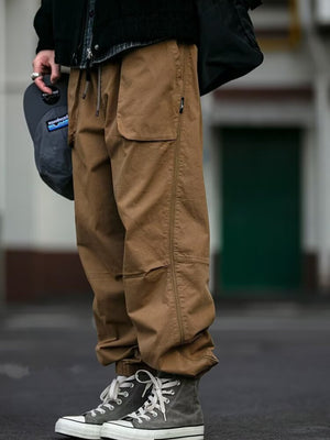 Caramel drawstring sweatpants with zippered pockets and elastic cuffs.