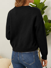 Black V-neck cardigan with daisy embroidery detail and button front, styled with jeans.
