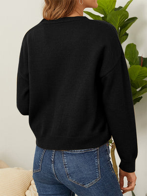 Black V-neck cardigan with daisy embroidery detail and button front, styled with jeans.
