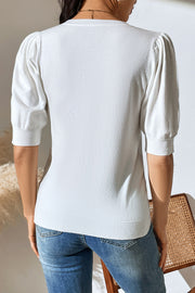 White knit sweater with puff sleeves and ribbed cuffs and hem.